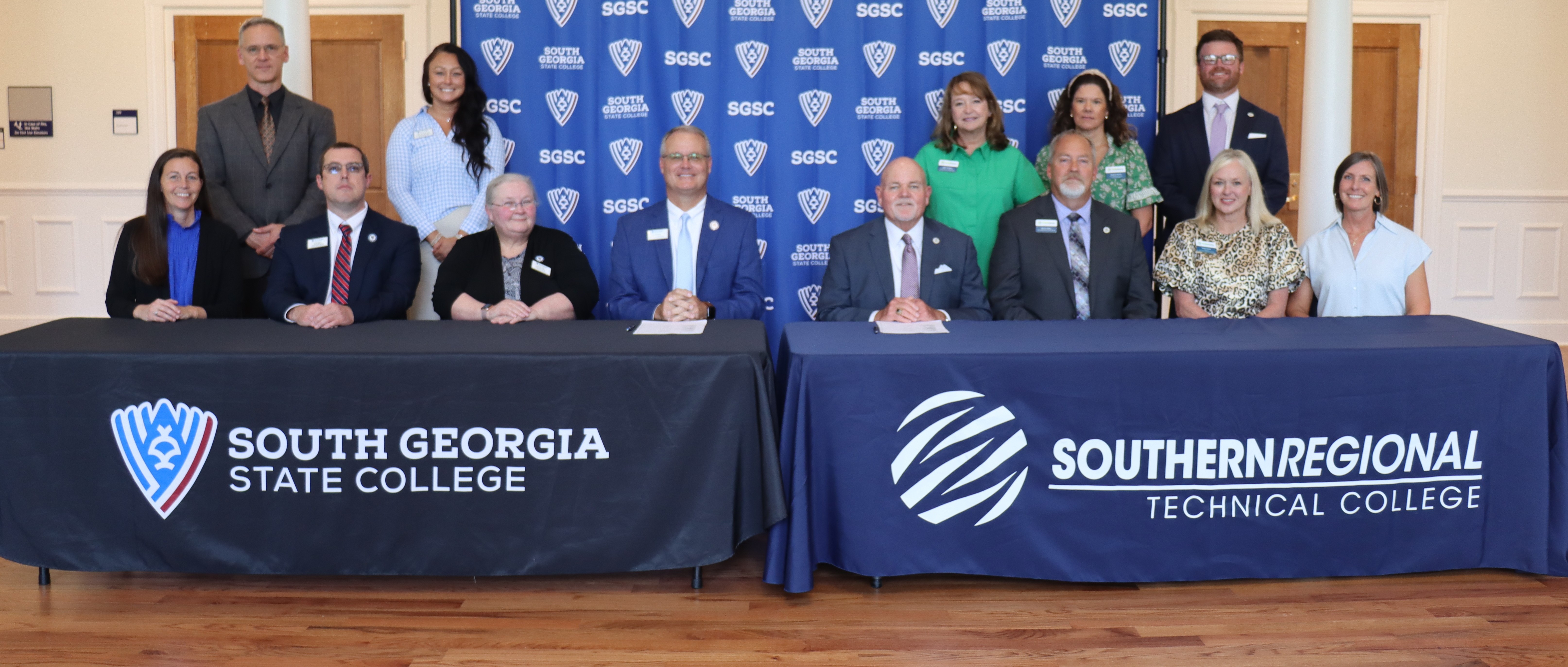 People at a table with branded materials to sign an agreement